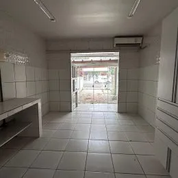 Foto de um corredor interno com piso de cerâmica branca e ar-condicionado instalado.