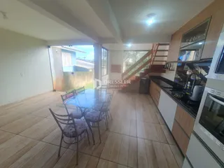 Sala de jantar com mesa de vidro e cadeiras em um imóvel no Brasil.