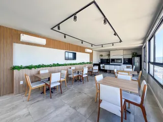 Uma sala de jantar moderna com mesa de madeira e cadeiras em um ambiente claro.