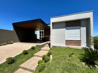 Fachada moderna de uma residência em Lajeado, Brasil, com jardim frontal e área coberta.