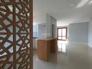 Ambiente moderno com piso claro e divisória de madeira em uma sala de estar.