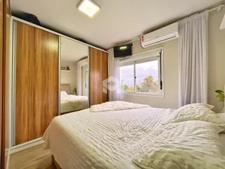 Quarto com armários de madeira e janela bem iluminada.