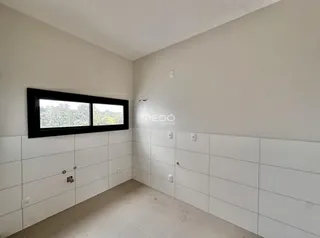 Uma parede interna com janela e revestimento branco.