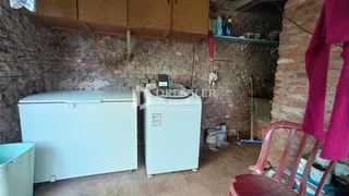 Foto de um ambiente interno com paredes de tijolo aparente e geladeiras brancas.