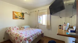 Uma foto de um quarto com cama e televisão montada na parede.