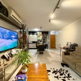 Uma sala de estar com televisão de tela plana e teto branco.