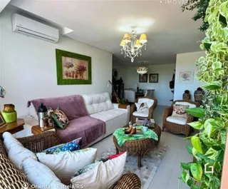 Sala de estar com sofá e móveis de vime em uma residência.