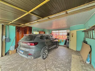 Interior de uma sala com piso de cerâmica e um carro estacionado.