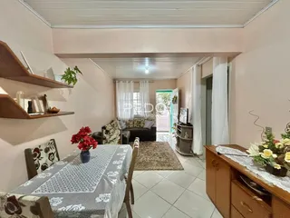 Ambiente interno com mesa de jantar e sala de estar em Lajeado.