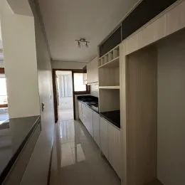 Hall de entrada com armários embutidos e piso claro.