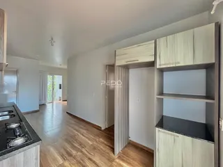 Hall de entrada com piso de madeira e armários em um imóvel no Brasil.