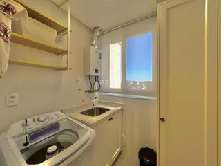 Vista de uma área de cozinha com pia e janela em um imóvel no Brasil.