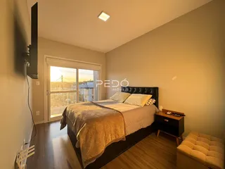 Quarto com cama e janela de madeira em um imóvel no Brasil.