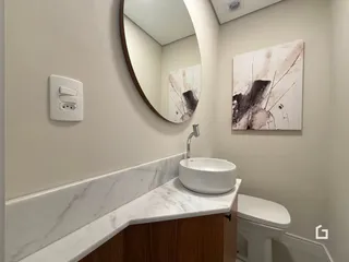 Banheiro moderno com bancada de mármore e vaso sanitário branco.
