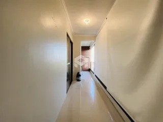 Foto de um corredor interno de uma residência.