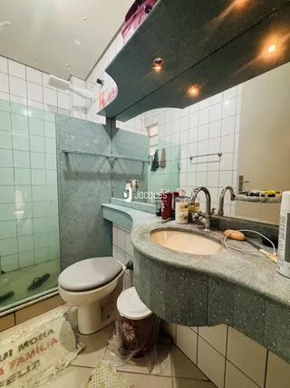 Foto de um banheiro com revestimento cerâmico e bancada de granito.