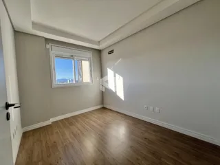 A sala apresenta paredes cinzas e piso de madeira clara.