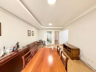 Sala de estar com móveis de madeira e paredes brancas.