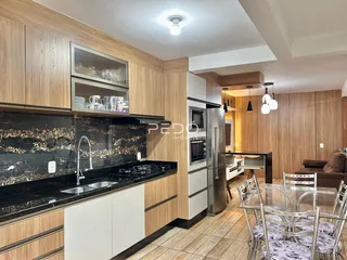 Cozinha moderna com armários de madeira e bancada escura.