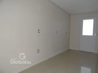 Vista interna de um corredor com paredes brancas e piso claro.
