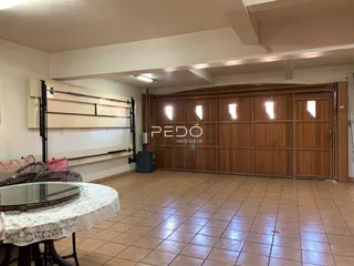 Interior de uma sala com piso de cerâmica e painel de madeira.