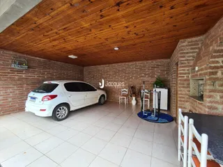 Espaço amplo com paredes de tijolo aparente e teto de madeira.