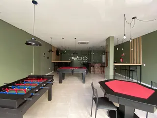 Ambiente interno com mesas de sinuca em um espaço amplo.