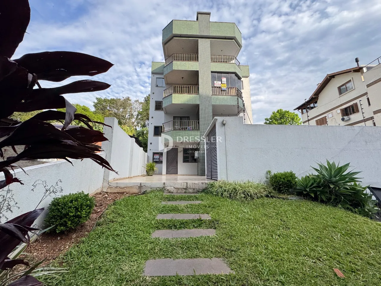 Fachada de um prédio residencial em Lajeado, Brasil, com jardim frontal.