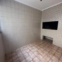 Parede interna com revestimento de azulejos brancos e piso de cerâmica em um ambiente.