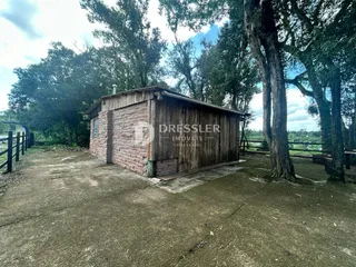 Exterior de uma construção de madeira e tijolo em uma propriedade.