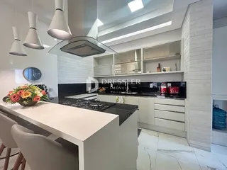 Uma cozinha moderna com armários brancos e bancadas escuras.