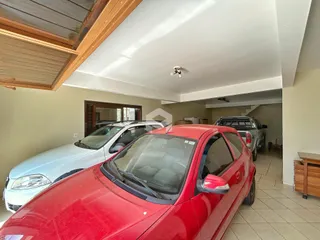 Interior de uma garagem ou área comum com dois carros estacionados.