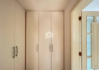 Armários brancos de closet em um ambiente interno.