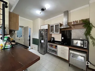 Vista da cozinha com armários de madeira e eletrodomésticos em Lajeado.