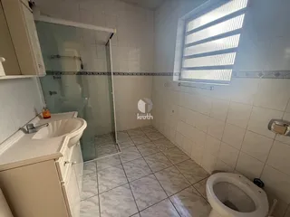 Banheiro com piso de cerâmica e box de vidro.