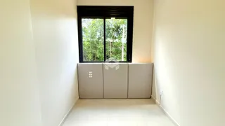 Um corredor interno com uma grande janela de vista para a natureza.