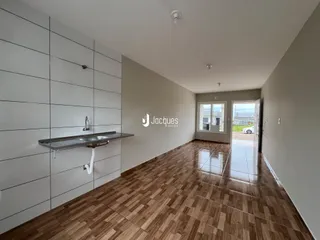Hall de entrada com piso de madeira e paredes brancas.