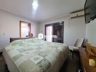 Quarto com cama grande e janela em um imóvel.