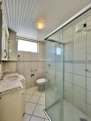 Foto de um banheiro com box de vidro e piso cerâmico em Lajeado.