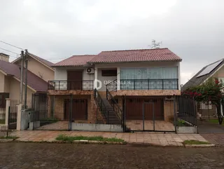 Fachada de uma casa em Lajeado, Brasil, com cerca e portão de ferro.
