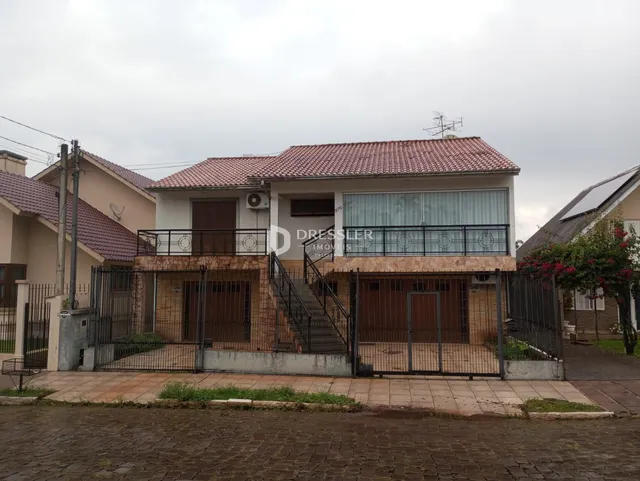 Fachada de uma casa em Lajeado, Brasil, com cerca e portão de ferro.