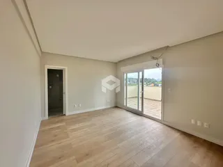 Vista interna de um ambiente com piso de madeira clara e paredes brancas.