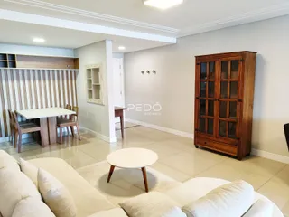 Sala de estar com área de jantar e móveis de madeira.