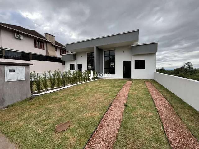 Fachada de uma casa moderna com jardim gramado em Lajeado, Brasil.