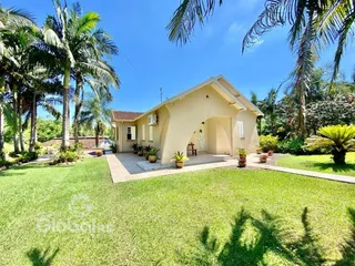 Fachada de uma casa em Lajeado, Brasil, com jardim verde e vegetação tropical.