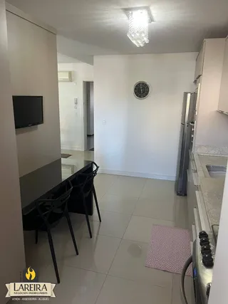 Ambiente interno de uma sala com piso de cerâmica e móveis escuros.