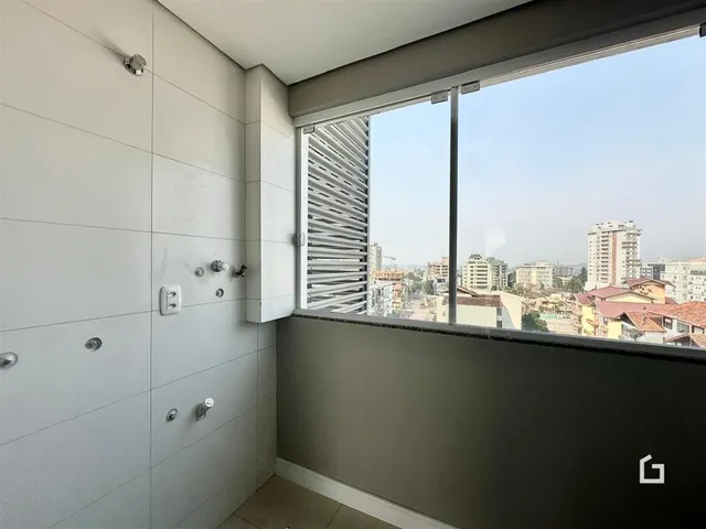 Parede interna de uma residência em Lajeado, Brasil, com uma grande janela de vista para a cidade.