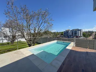 Vista de uma piscina externa em um terraço com vista para a paisagem.