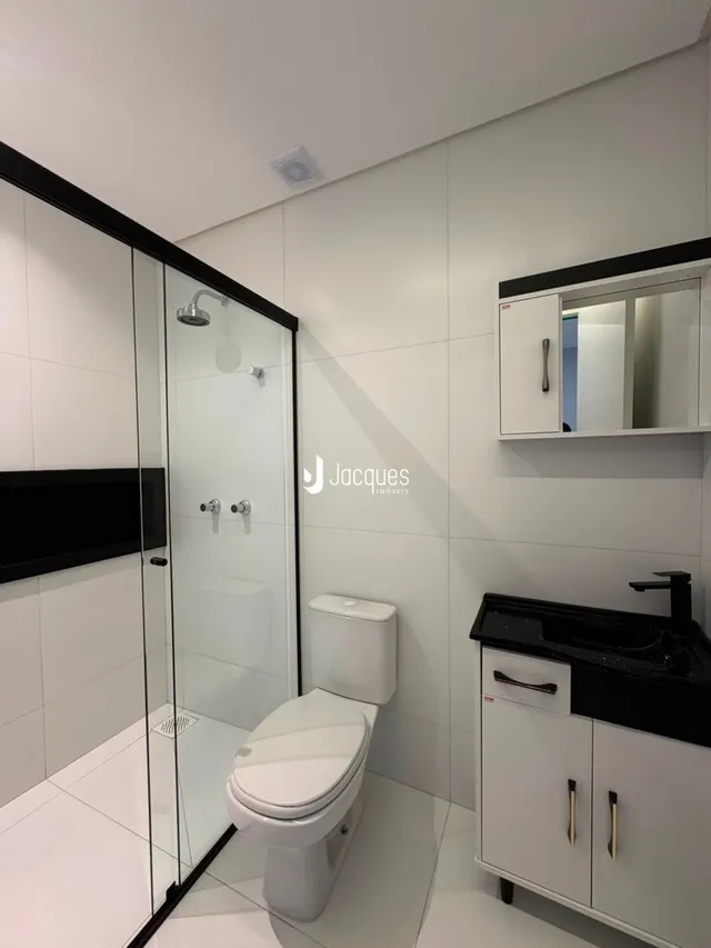 Foto de um banheiro moderno com piso de cerâmica e box de vidro.