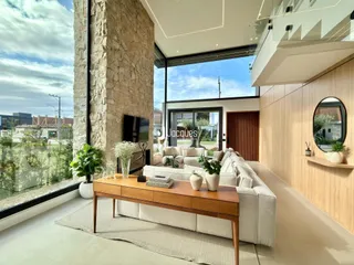 Sala de estar moderna com grande janela e vista para o exterior.